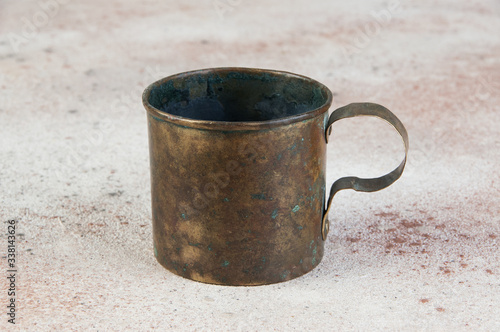 Old brass mug with handle on concrete background © voisine574