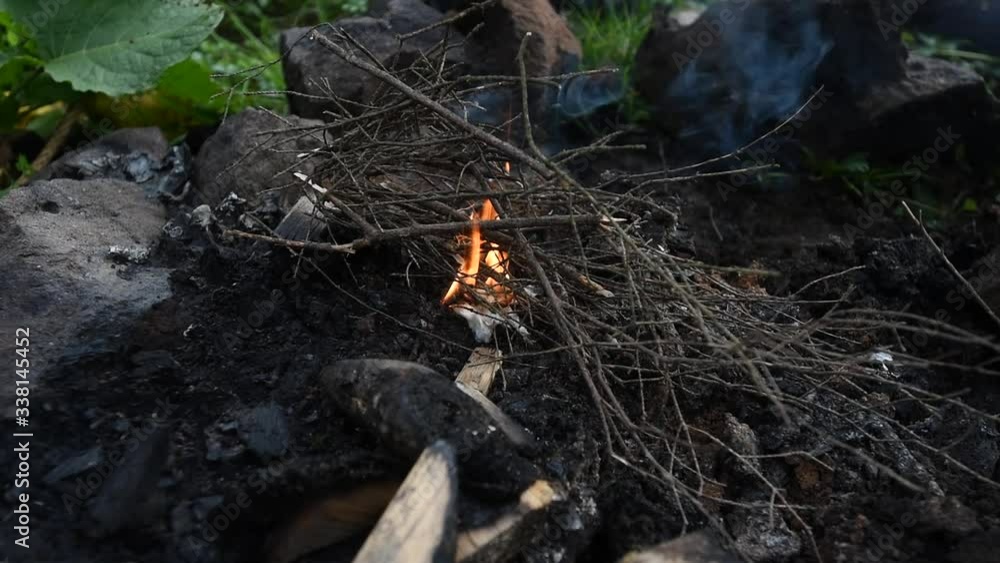 Male hiking tourist kindling firewood in Carpathian forest Male hiking tourist kindling firewood in Carpathian forest