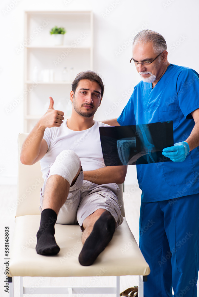 Obraz premium Leg injured man visiting old doctor in first aid concept