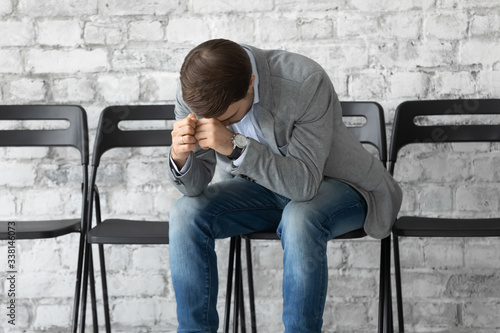 Obraz na plátně Upset male job candidate sit on chair in office hallway worried before interview