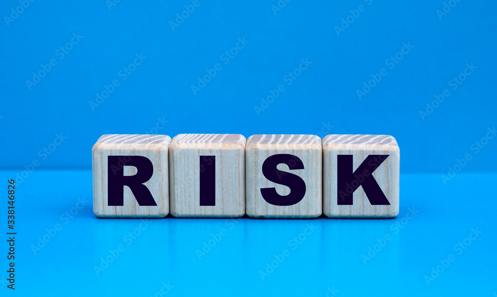 concept word RISK on cubes on a blue background concept word RISK on cubes on a blue background