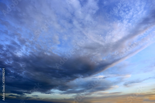 Fototapeta Naklejka Na Ścianę i Meble -  Burzowe chmury na błękitnym niebie w czasie zachodu słońca.	
