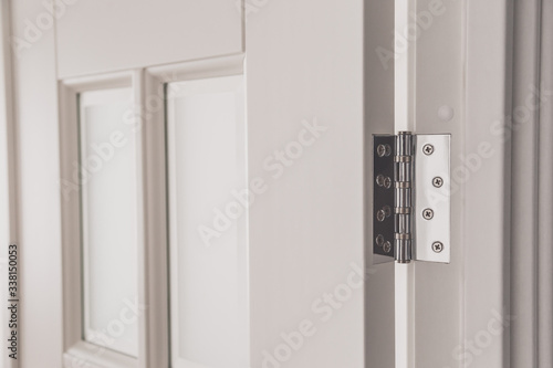 stainless door mortised hinge on a white door photo