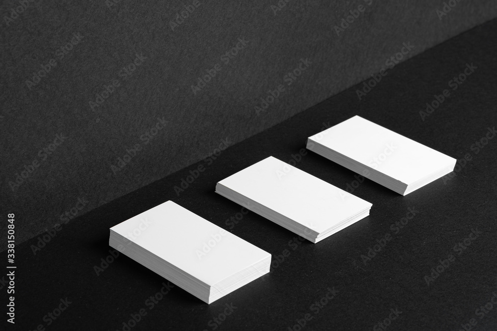 Stacked white businesscards for branding identity on black background, copy space Stacked white businesscards for branding identity on black background, copy space