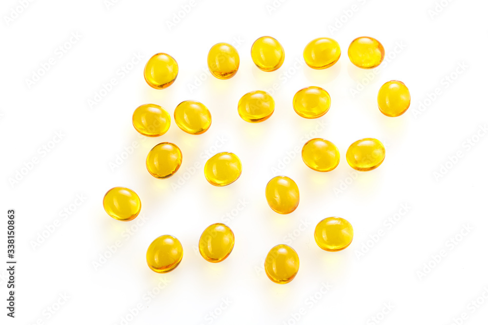 Yellow gel capsules pills. Capsules with yellow medicine on isolated white background. A lot of capsules vitamin D close-up . Bright oil yellow pills.