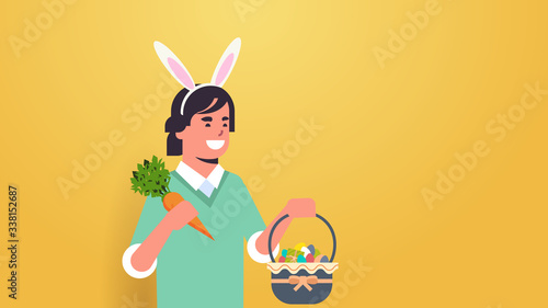 man wearing bunny ears cute guy holding carrot and basket with eggs celebrating happy easter holiday concept horizontal portrait vector illustration