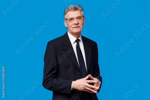 Stylish and fashion bearded man in suit and tie isolated on blue background. Business style, and fashionable image