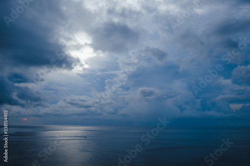 Beautiful blue sunset on the ocean with big waves and cliffs and cliffs. Bali island with its tropical and exotic nature. Sunrise over the sea and ocean. Phantom blue in sunset