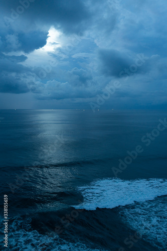 Beautiful blue sunset on the ocean with big waves and cliffs and cliffs. Bali island with its tropical and exotic nature. Sunrise over the sea and ocean. Phantom blue in sunset © Underwater girls
