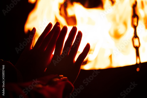 woman warming her hands by the campfire