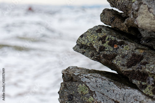 lichen covered rock cairn close up resembling fantasy creature in focus with blurred background in Norway, on route to Vidden, Scandinavian nature in winter photo