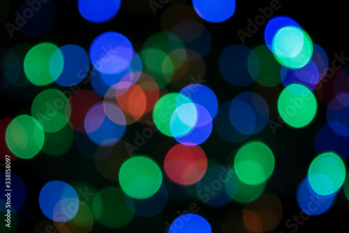 Bright abstract bokeh on a black background. Blurred background