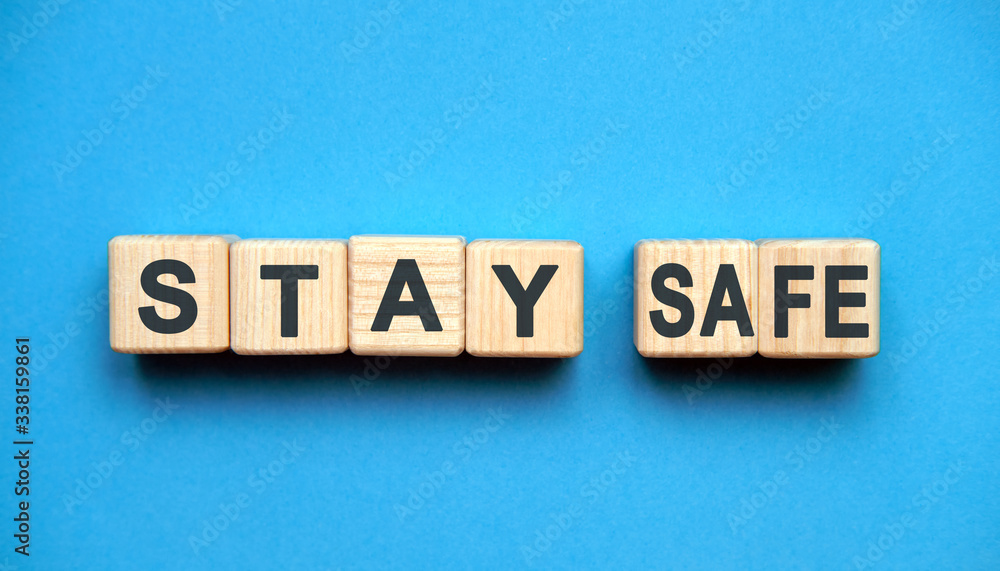 STAY SAFE text on wooden blocks, MEDICAL concept, blue background STAY SAFE text on wooden blocks, MEDICAL concept, blue background