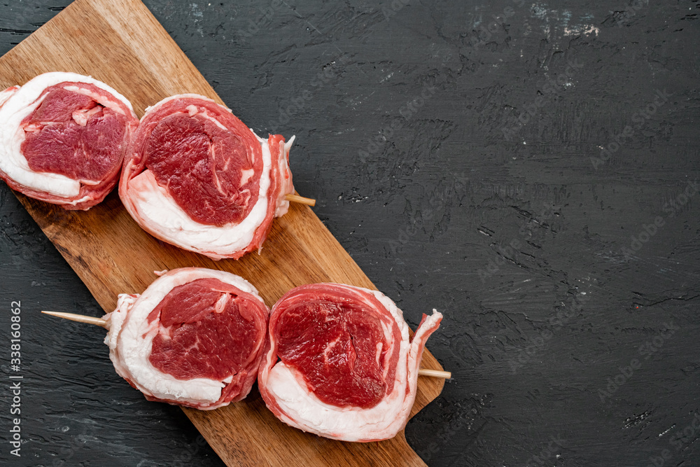 Raw beef steak on a dark wooden table