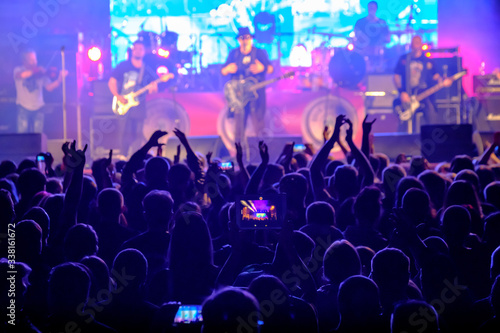 Fans at live rock music concert cheering