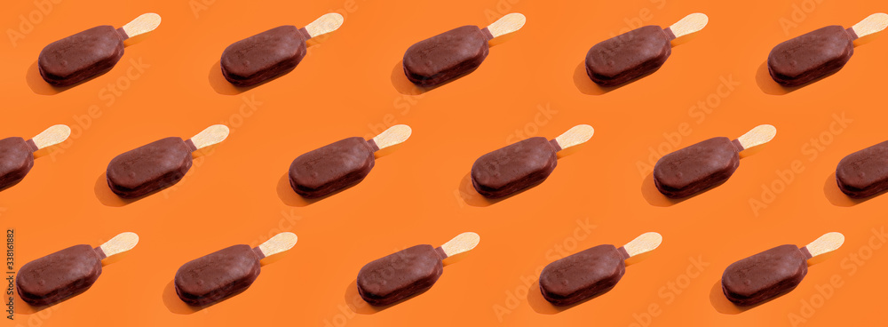 Ice cream chocolate popsicles pattern on trendy vivid orange background Ice cream chocolate popsicles pattern on trendy vivid orange background