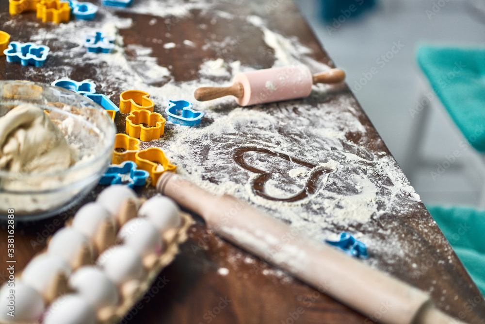 Dough, eggs, rolling pin, and other baking items on the kitchen table. From bakery with love