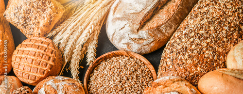 Various kind of bread with wheat top view. White bakery food concept panorama or wide banner photo.