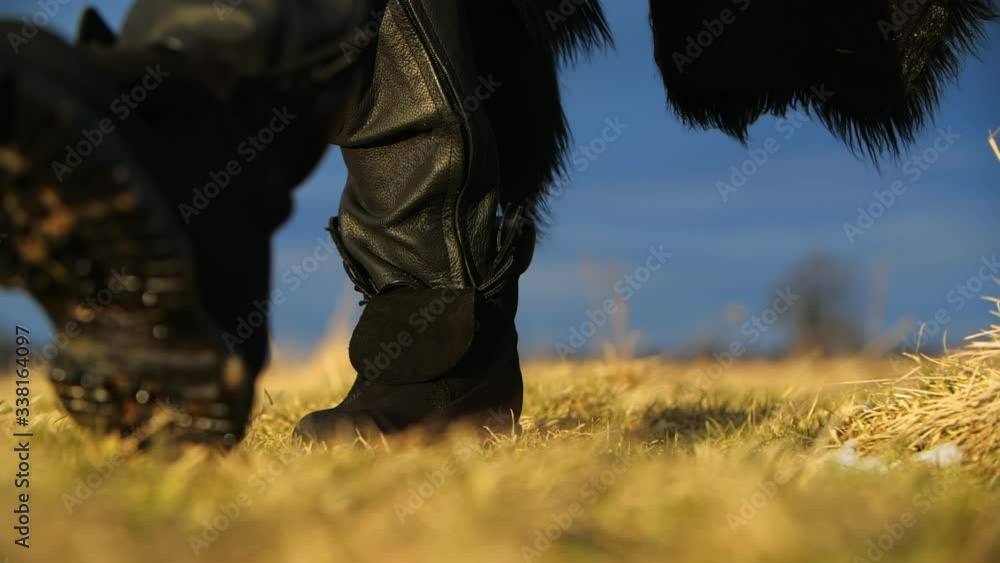 man in boots making step on the dry grass. Ukraine