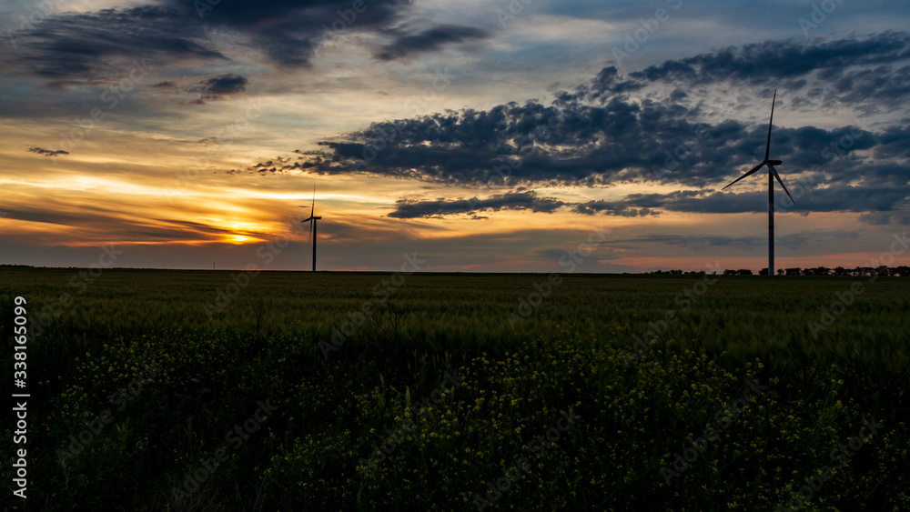 wind generator in grass field at sunset wind generator in grass field at sunset