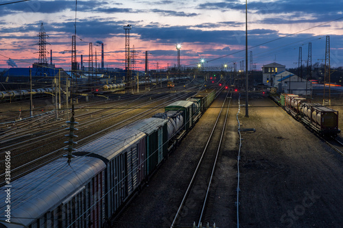 Multi-track Railway with a freight train in the evening against a background of beautiful pink sunset and beautiful sky