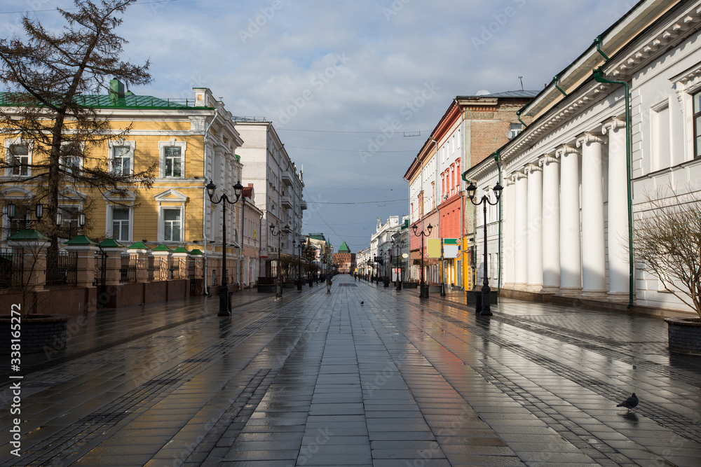 Bolshaya Pokrovskaya street in Nizhny Novgorod without people after rain with reflections of buildings on the paving stones in the rays of the spring sun
