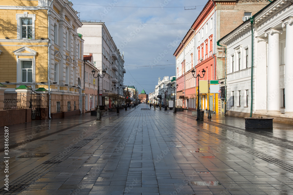 Bolshaya Pokrovskaya street in Nizhny Novgorod without people after rain with reflections of buildings on the paving stones in the rays of the spring sun