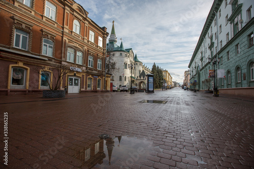Bolshaya Pokrovskaya street in Nizhny Novgorod without people after rain with reflections of buildings on the paving stones in the rays of the spring sun photo