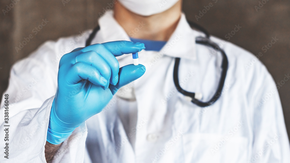 Doctor or pharmacist hand holds capsule with medicine Doctor or pharmacist hand holds capsule with medicine