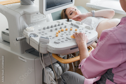 Close-up ultrasound device during a medical examination of a pregnant woman. Medical examination