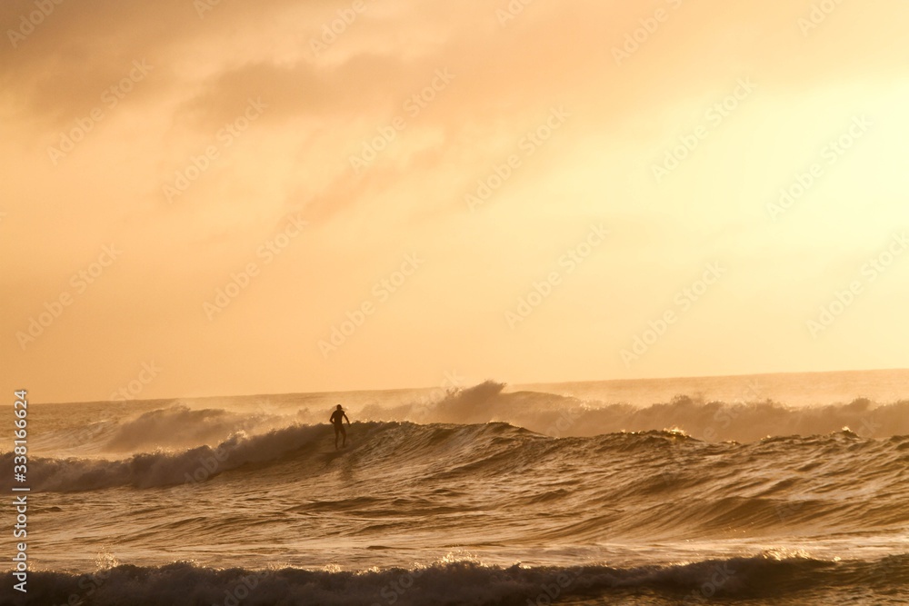 Man surfing in sea during sunset