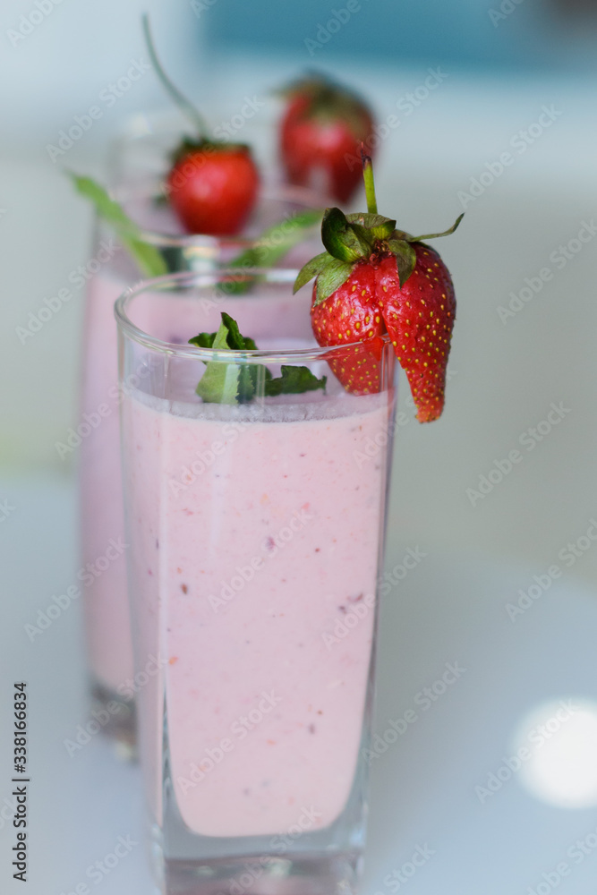 Closeup of strawberry fruit smoothies with strawberry pieces in glass Closeup of strawberry fruit smoothies with strawberry pieces in glass