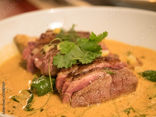 delicious piece of meat with orange sauce on white plate