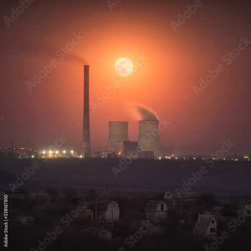 The red full moon rising over the power plant