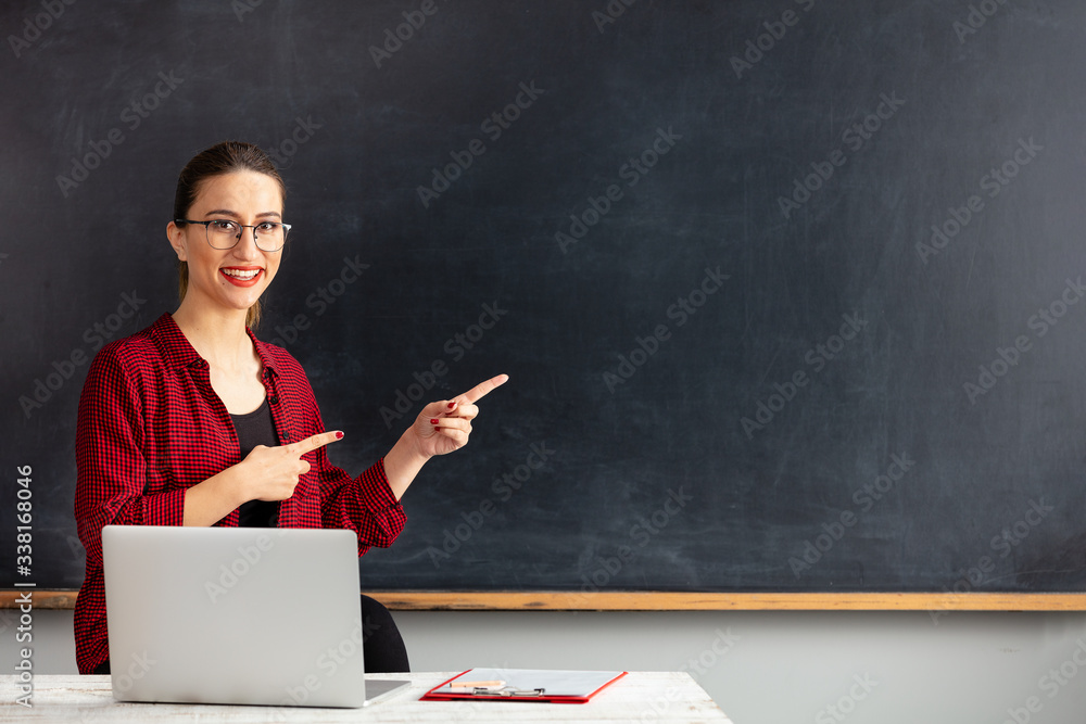 Young woman teacher pointing empty blackboard. Young woman teacher pointing empty blackboard.