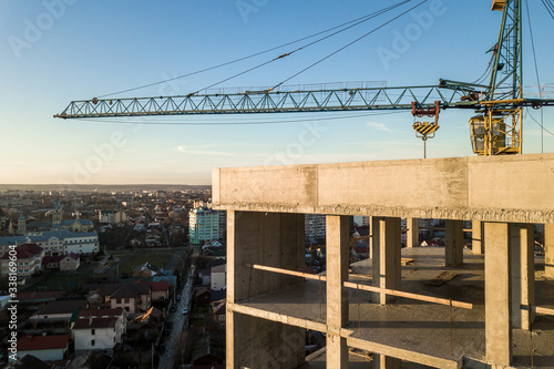 Aerial view of concrete frame of tall apartment building under construction in a city.