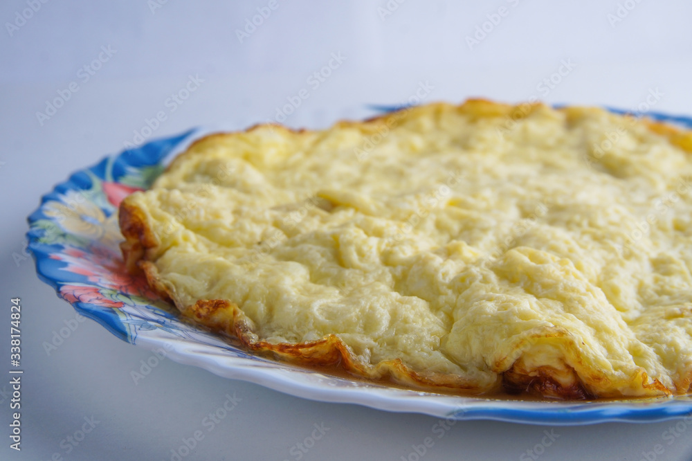 large omelet on a colorful plate on a white background large omelet on a colorful plate on a white background