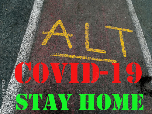 COVID-19 written, STAY HOME on ALT signal painted on a cycle path in perspective view. conceptual image for the current pandemic photo