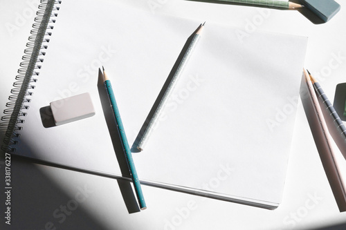 Mockup, sketch. Album pages, pencils for drawing and eraser on a table.