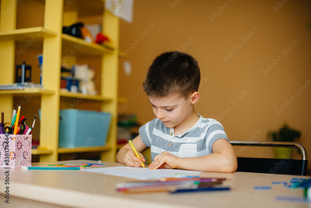 A school-age boy does homework at home. Training at school A school-age boy does homework at home. Training at school