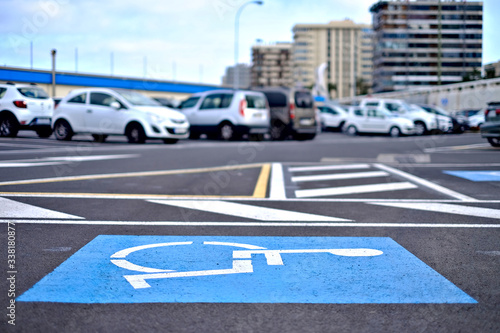 International Symbol of Access, a blue person in a wheelchair symbol painted on an allocated parking lot.