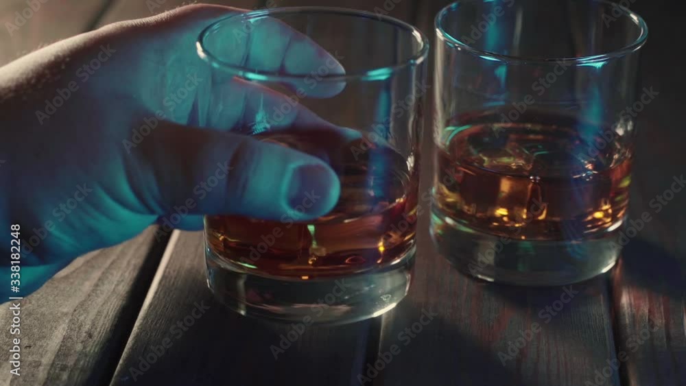 Alcohol drink. Male hand takes glass of whiskey or rum or other alcohol Alcohol drink. Male hand takes glass of whiskey or rum or other alcohol