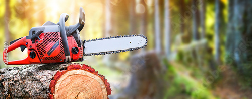 Chainsaw on wooden stump or firewood. photo