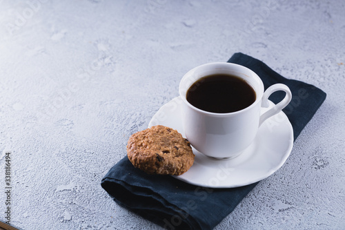 White cup of coffee with oatmeal cookies and coffee maker, breakfast concept, selective focus