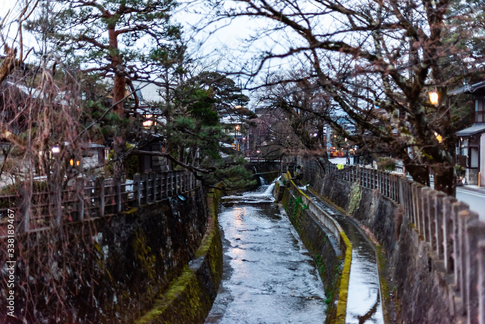 Takayama, Japan small town and Enako river in Gifu prefecture in Japan with water in early spring in traditional village at night