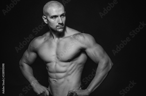 Sporty guy posing in the Studio on the background. Sports, beauty, black and white photography