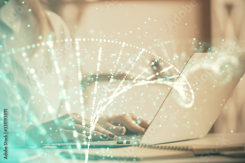 Double exposure of woman hands typing on computer and DNA hologram drawing. Medical education concept.