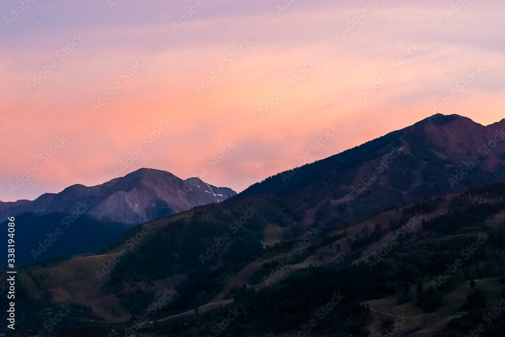 Pink orange sunset in Aspen, Colorado with rocky mountains peak in autumn and vibrant pastel color at twilight