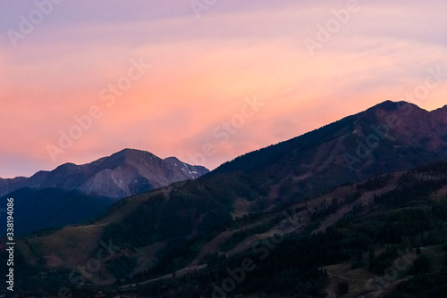 Pink orange sunset in Aspen  Colorado with rocky mountains peak in autumn and vibrant pastel color at twilight