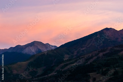 Pink orange sunset in Aspen, Colorado with rocky mountains peak in autumn and vibrant pastel color at twilight